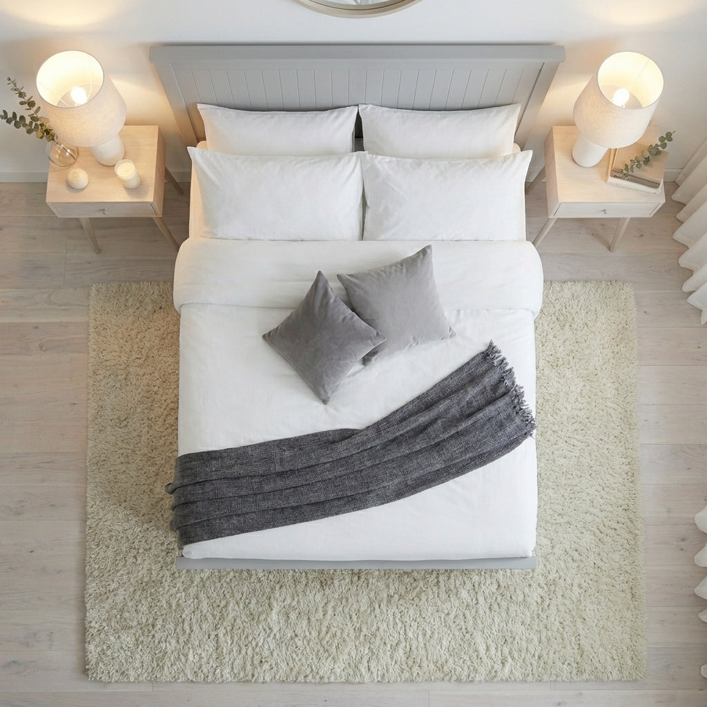 Neatly made bed with white bedding and gray throw blanket in a bedroom setting | Dove Grey